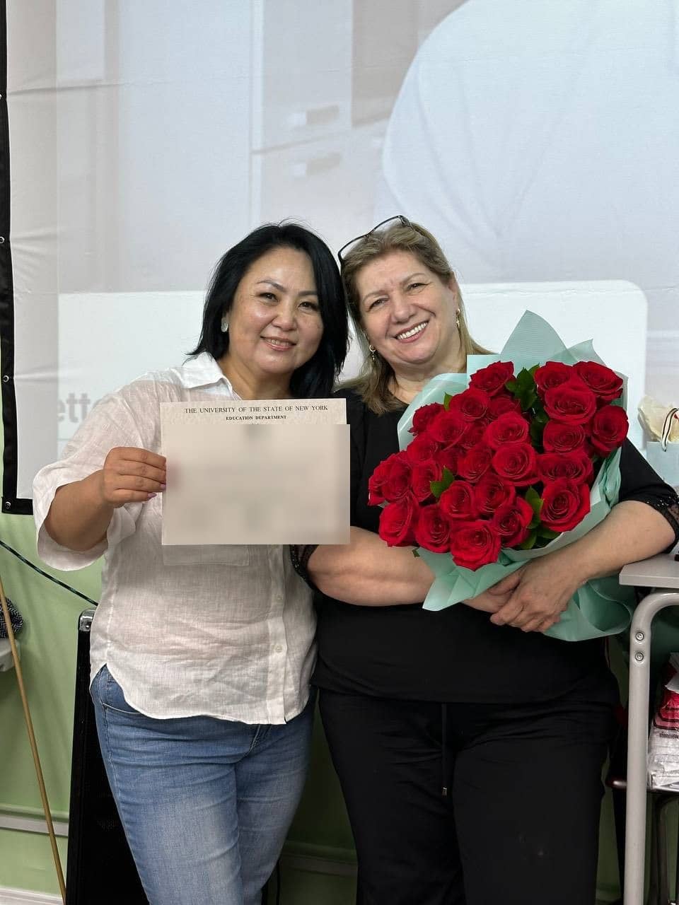 Ninara Ibragimova with roses next to a student holding up a New York State certificate